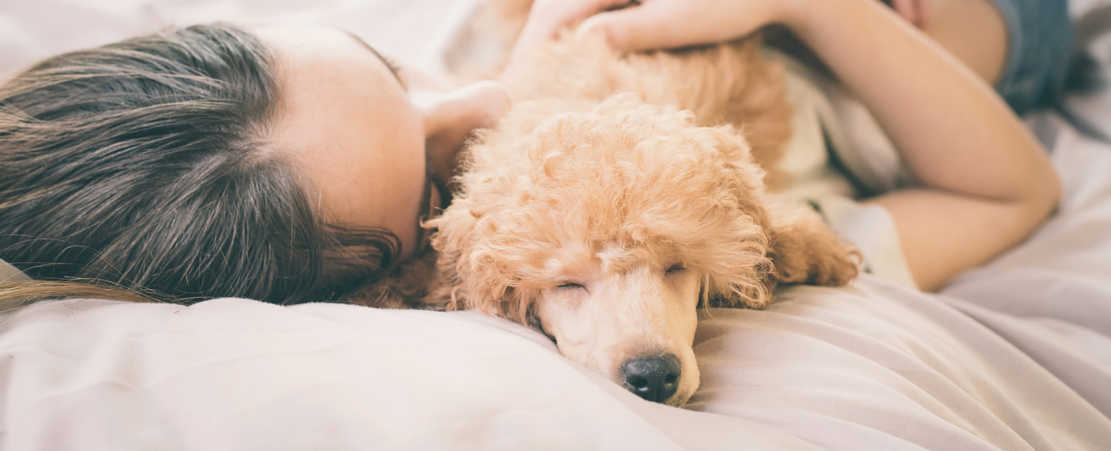 Frau kuschelt mit kleinem Hund